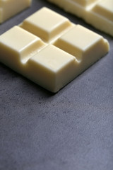 White chocolate pieces on gray background