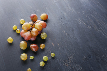 Juicy green and purple grapes, on wooden background