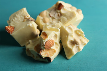 White chocolate pieces on color wooden background