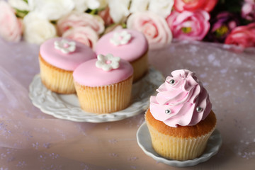 Tasty cupcakes on bright background