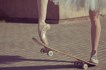 The legs of a ballerina on a skateboard.