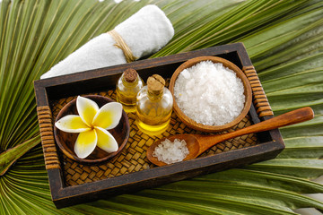 Obraz na płótnie Canvas Wooden bowl of flower with , oil, spoon ,salt,oil,towel on green palm