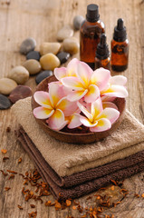Fototapeta na wymiar frangipani and dry flower petals ,towel ,oil on old wood