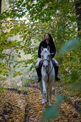 Woman riding a horse in the forest