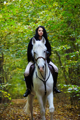 Woman riding a horse in the forest