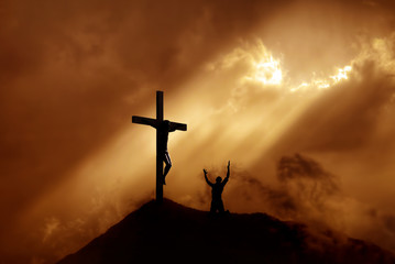 Dramatic sky scenery with a mountain cross and a worshiper - obrazy, fototapety, plakaty