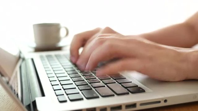 4K Woman's hands typing on modern laptop PC, then holding up a coffee cup and put it down. 