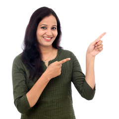 Happy young woman whowing copy space against white