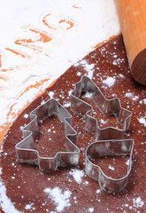 Cookie cutters and rolling pin on dough for cookies and gingerbread