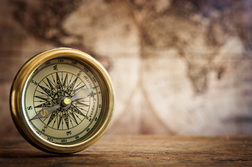 Old compass on vintage map. Retro stale.