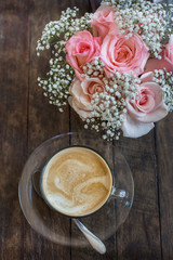 hot coffee and bouquet of flower on grunge wood table