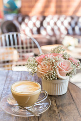 hot coffee and bouquet of flower on grunge wood table