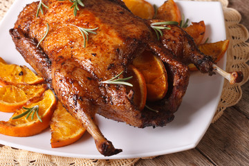 whole roast duck with oranges and rosemary close up. horizontal
