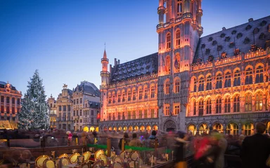 Zelfklevend Fotobehang Lichtshow op de Grote Markt van Brussel, België en een enorme kerstboom met een menigte niet-geïdentificeerde mensen die genieten van de feestelijke sfeer © ANADMAN
