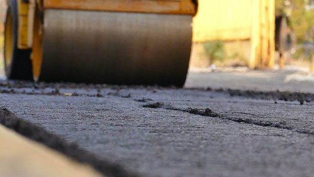 Road roller doing road repair and paving of streets, Slow Motion Video clip