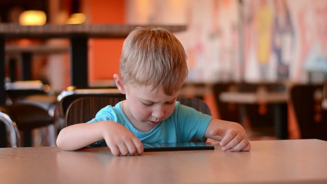 The boy with the tablet in cafe. Time lapse

