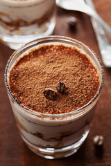 Tiramisu in glass on vintage table, traditional coffee flavored Italian dessert made of ladyfingers and mascarpone