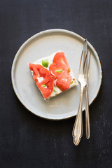 Sandwich with cream cheese, beef tomato slices and basil leaves