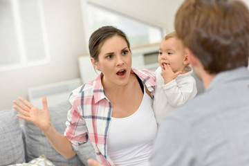 Man and woman arguing in front of baby