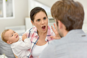 Man and woman arguing in front of baby