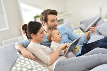 Family with baby in sofa watching tv