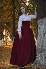 Fototapeta premium Woman dressed in a retro-style on the autumn alley