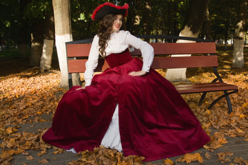 Fototapeta premium Woman dressed in a retro-style on the autumn alley