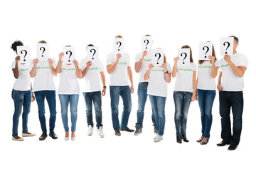 Obraz premium Volunteers Covering Faces With Question Mark Signs