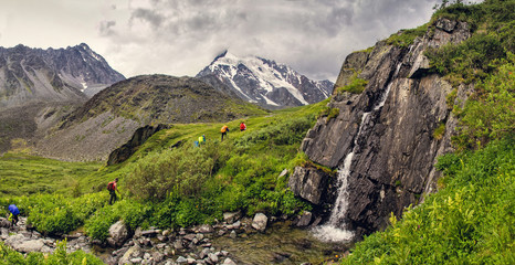 Hikers in mountains with waterfall