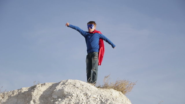 superhero  boy  runs through the mountains and trying to fly