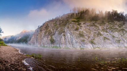 mountain river among rock walls in fog