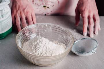 Man sifting flour for pizza dough