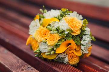 Yellow wedding bouquet on a bench