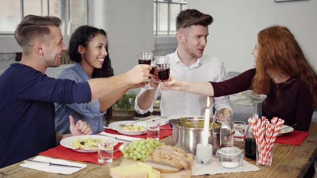 freunde treffen sich zu hause, essen zusammen und trinken rotwein