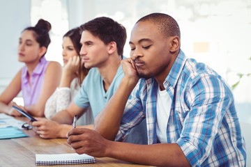 Young creative worker bored in meeting