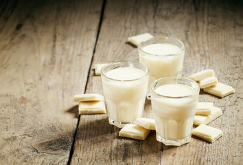 White chocolate mousse in small cups and pieces of chocolate on