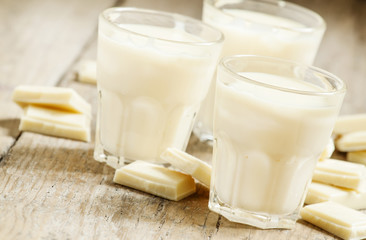 White chocolate mousse in small cups and pieces of chocolate on