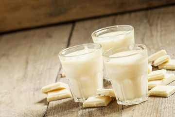 White chocolate mousse in small cups and pieces of chocolate on