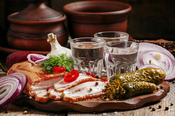 Russian tradition: cold vodka and a snack of bacon, pickles, red