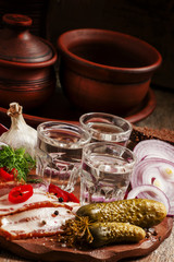 Russian tradition: cold vodka and a snack of bacon, pickles, red