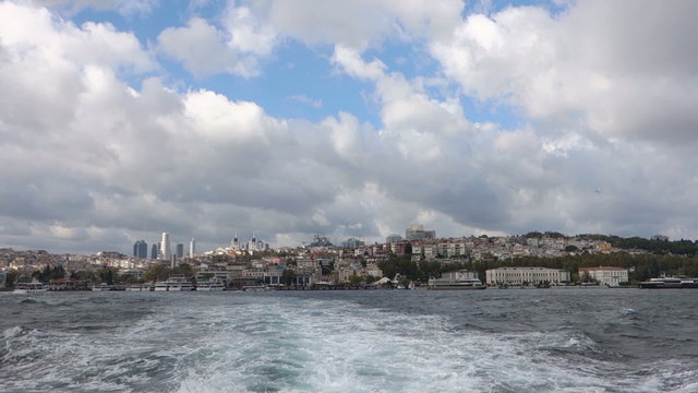 Crossing the Bosphorus Strait at the back of a passenger boat in Istanbul Turkey. Looking through the West part of the city, Besiktas district.