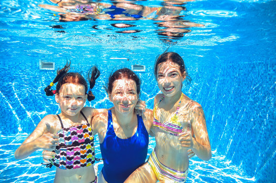 Family swim in pool underwater, happy active mother and children have fun in water, kids sport on family vacation
