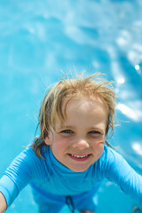 Fototapeta na wymiar Happy little boy in the swimming pool