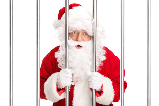 Sana Claus standing behind bars in jail