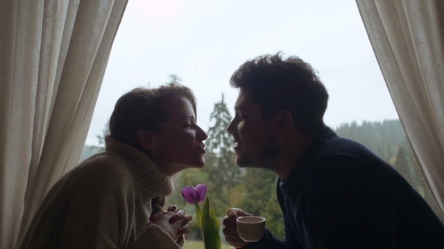 Young couple kissing while having a romantic dinner. Beautiful couple in love spending romantic time.