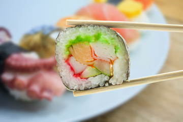 sushi maki in chopsticks