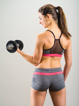 Sexy Young Woman Doing Dumbbell Curl