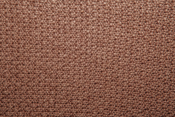 Seed stitch in brown yarn as an abstract background texture