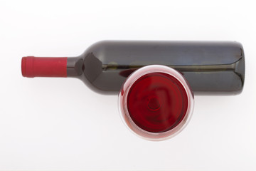 Glass and bottle of red wine. Top view unusually on white background.