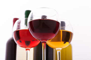 Glasses and bottles of wine unusually on white background.